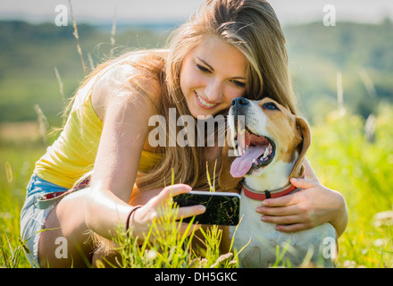 Teen girl taking photo of herself and her dog with mobile phone camera  Stock Photo - Alamy