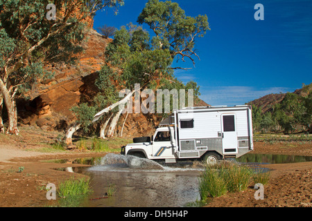 Campervan crossing Ross River near camping area, NT Stock Photo