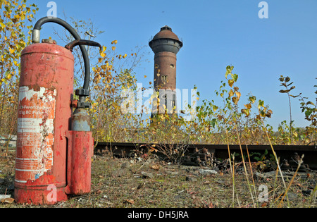 Abandoned fire extinguisher in front of the historic Wasserturm Nord water tower, abandoned marshalling yard in Duisburg Wedau, Stock Photo