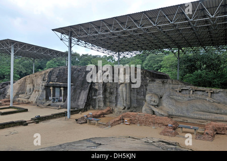 Buddha statue with meditation gesture Dhyana or Samadhi mudra, in the middle a standing statue with folded arms, historians and Stock Photo