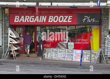 Man entering Bargain Booze Plus off license shop, Bowness Stock Photo