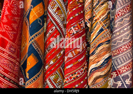 Colourful woven rugs with traditional patterns of the Arab or Berber people for sale in the souks or bazaar area of Marrakech Stock Photo