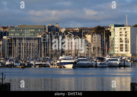 Yachts moored in Sutton Harbour, Plymouth, Devon, England, with apartments behind, on an October evening Stock Photo