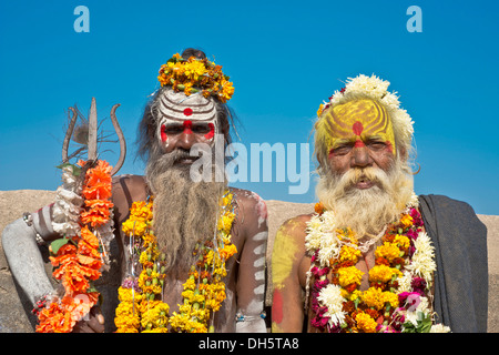 Two sadhus, holy men with a typical face painting, one holding a Trishula trident, Orchha, Madhya Pradesh, India Stock Photo