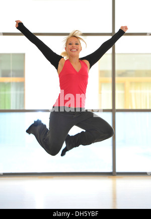 Young woman dancing, leaping into the air, symbolic image of vitality, Haus des Sports, House of Sport, SpOrt, Stuttgart Stock Photo