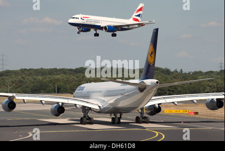 Lufthansa Airbus A340-300 waiting for incoming British Airways Airbus A320 to land at Dusseldorf International airport Germany Stock Photo