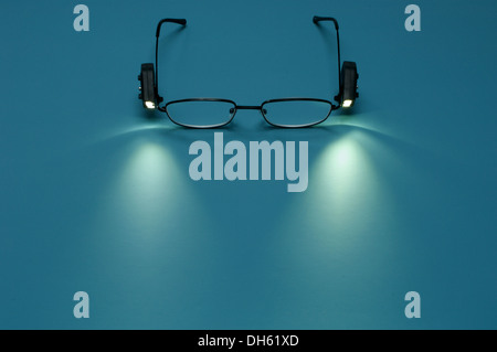 A pair of reading glasses with small attached lights