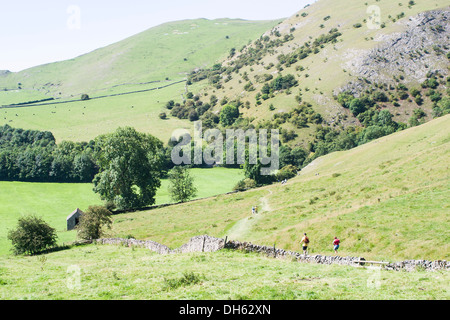 Holidaymakers and hikers enjoy a ramble in the beautiful Peak District National Park scenery around Dove Dale Stock Photo