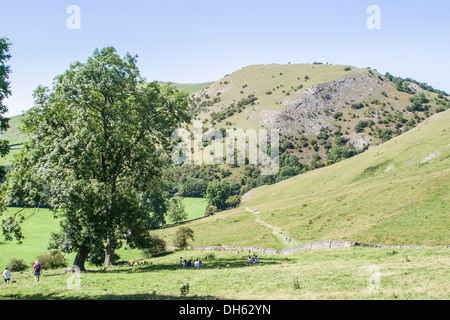 Holidaymakers and hikers enjoy a ramble in the beautiful Peak District National Park scenery around Dove Dale Stock Photo