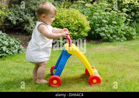 Nine Month Old Girl Learning To Walk With Baby Walker Toy In Garden England Uk Stock Photo Alamy