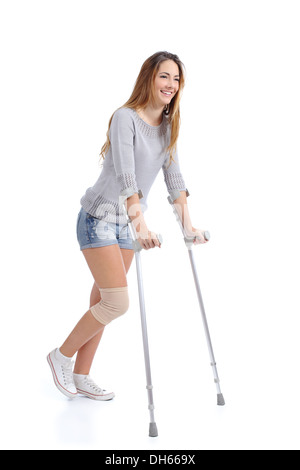 Beautiful woman smiling and hobbling with crutches isolated on a white background Stock Photo