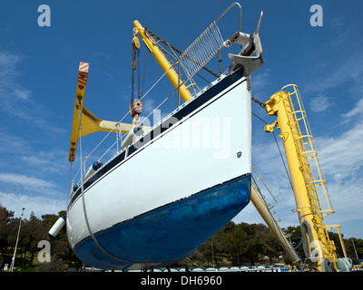 sailboat hanging on crane in harbor service Stock Photo