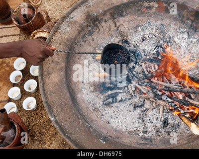 Bedouin roasting coffee beans over a fire to prepare Bedouin-style coffee, desert peoples from Egypt meeting in Wadi el Gamal Stock Photo