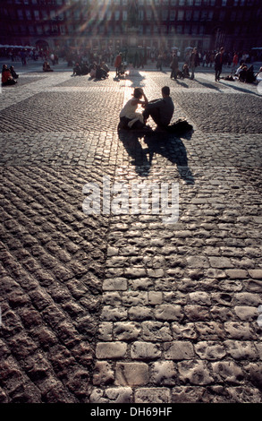 Couple sitting on the cobblestones of the Plaza Mayor, Madrid, Spain, Europe Stock Photo