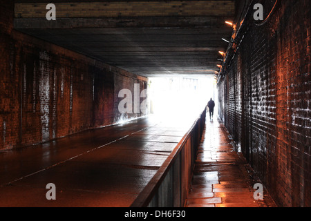 man walking through tunnel Stock Photo