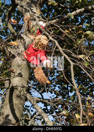yarn bombed tree with monkey made from straw and a woolen top Stock Photo