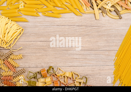 Different italian pasta with text space on a wooden board Stock Photo