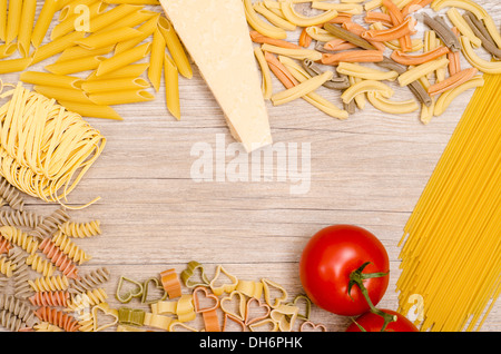 Italian pasta with tomato and parmesan cheese on wooden table Stock Photo
