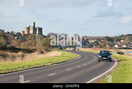 Car on the Coast and Castles route passes Warkworth Castle, Northumberland, England, UK Stock Photo