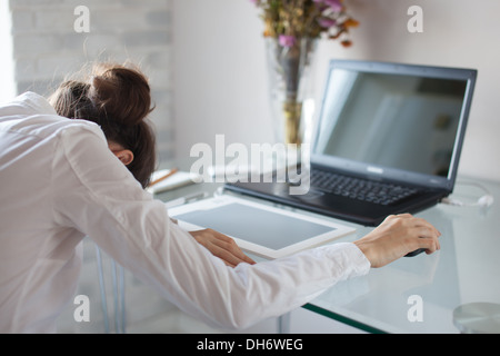 Tired woman sleeping on workplace Stock Photo