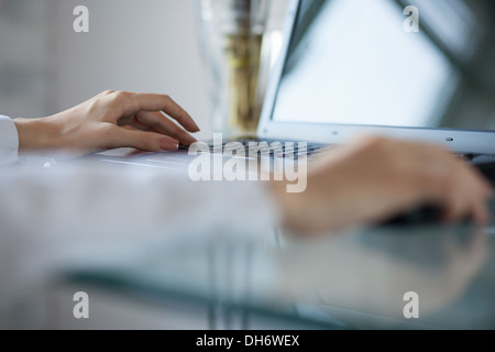 Woman's hand using cordless mouse on glass table Stock Photo