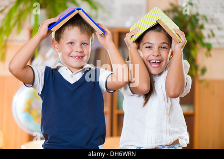 Two happy schoolchildren have fun in classroom at school Stock Photo