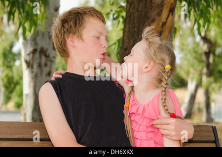 Happy childhood: two cute friends boy and girl hugging in park Stock Photo