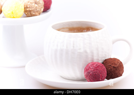 chocolate and raspberry truffles on the plate near coffee cup Stock Photo