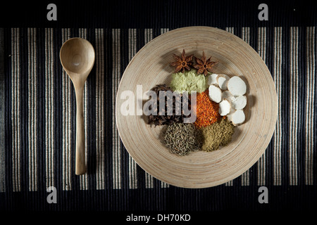 Chinese condiments placed in a wood plate with a wood spoon aside Stock Photo