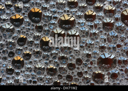 Bubbles with spectral colors being diffracted through thin surface film and refraction of light in water floating on top Stock Photo