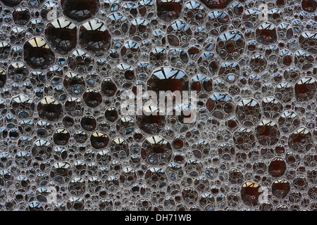 Bubbles with spectral colors being diffracted through thin surface film and refraction of light in water floating on top Stock Photo