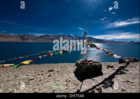 Stone pyramid and Buddhist praying flags. Himalaya mountains landscape with Tso Moriri lake. India, Ladakh, altitude 4600 m Stock Photo