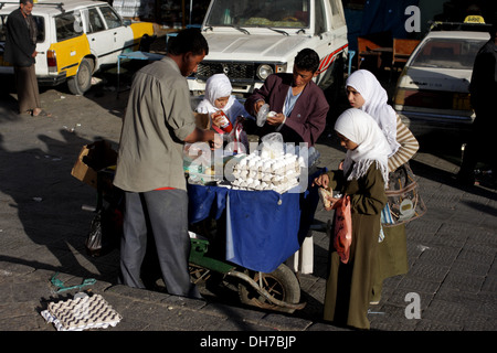 Children buying food at a street stall, Sanaa, Yemen Stock Photo