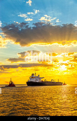 Tug boat pulling the tanker ship at sea. Stock Photo