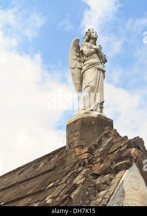 An angel statue sits atop a tomb in Lafayette Cemetery #2 in New Orleans, Louisiana Stock Photo