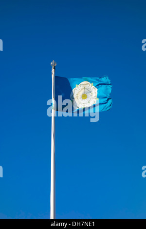 Official Yorkshire county flag with a white rose on a blue ground flying in a stiff breeze Stock Photo