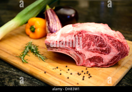 Raw Wagyu Beef Rib Roast with Rosemary, Bell Pepper and peppercorn on cutting board. © Craig M. Eisenberg Stock Photo
