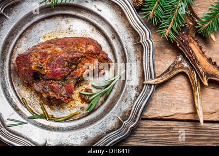 Roasted venison served on an old metal plate Stock Photo