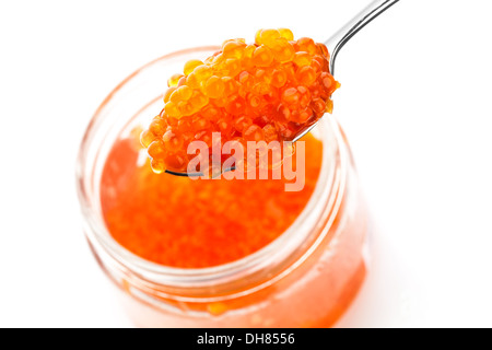 Red caviar in metal spoon and full glass jar isolated on white Stock Photo