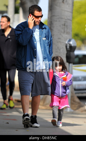 Adam Sandler talks on his cell phone whilst out in Santa Monica with his daughter Sunny Los Angeles California - 23.03.12 Stock Photo