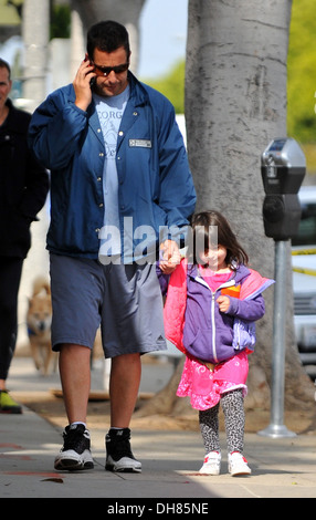 Adam Sandler talks on his cell phone whilst out in Santa Monica with his daughter Sunny Los Angeles California - 23.03.12 Stock Photo