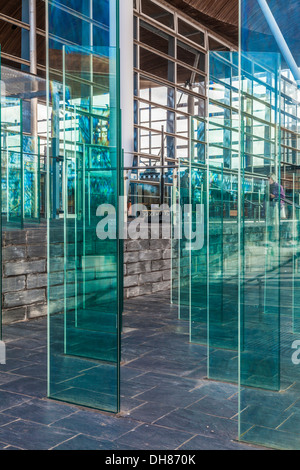 The Assembly Field outside the Senedd in Cardiff Bay Wales. Modern glass panels form a wind break, both functional and artistic. Stock Photo