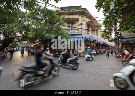 Shot of many scooter and mopeds in the Old Quarter of Hanoi, longer exposure captures motion of scooters. Stock Photo