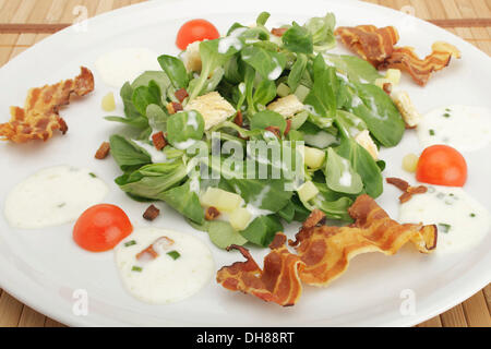 Field salad with potato dressing, bread croutons and fried bacon
