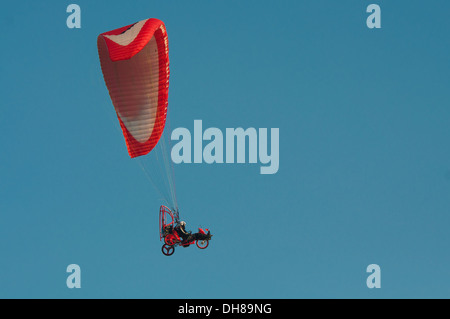 Paraglider flying over the clear blue sky Stock Photo