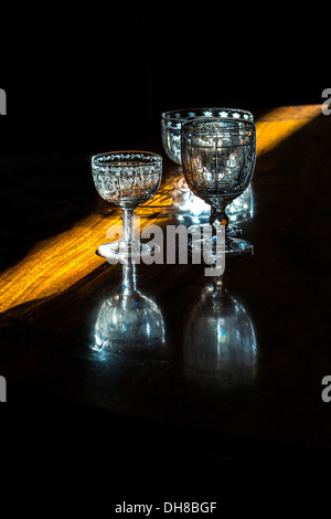Sunlight from a crack in the curtains across a dining room table with glasses. Stock Photo