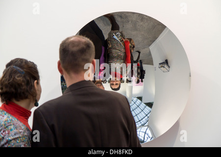 Couple looking themselves in a mirror by Anish Kapoor at the Fiac 2013 (contemporary art fair) at le Grand Palais in Paris Stock Photo