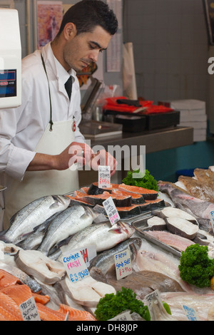 Fish Monger and stall of wares. Beresford Fish Market. Beresford Street, St. Helier, Jersey, Channel Islands. England. UK. Stock Photo