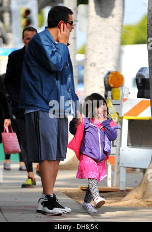 Adam Sandler talks on his cell phone whilst out in Santa Monica with his daughter Sunny Los Angeles California - 23.03.12 Stock Photo