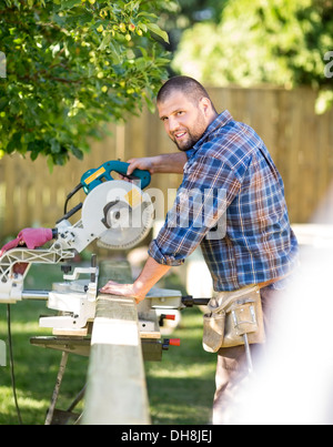 Manual Worker Cutting Wood Using Table Saw At Site Stock Photo